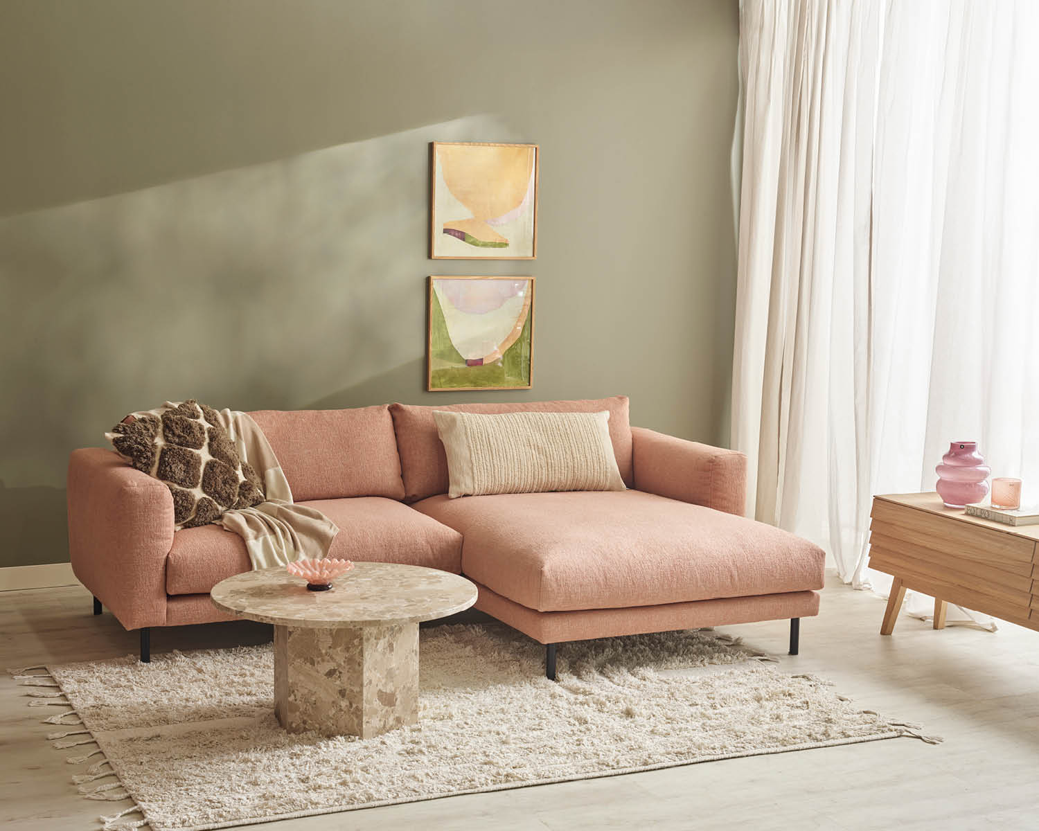 Rosa divansoffa i ett grönt rum