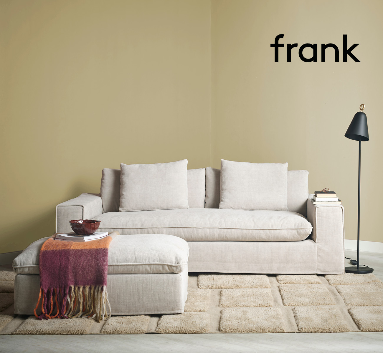 Beige soffa med fotpall i gult rum
